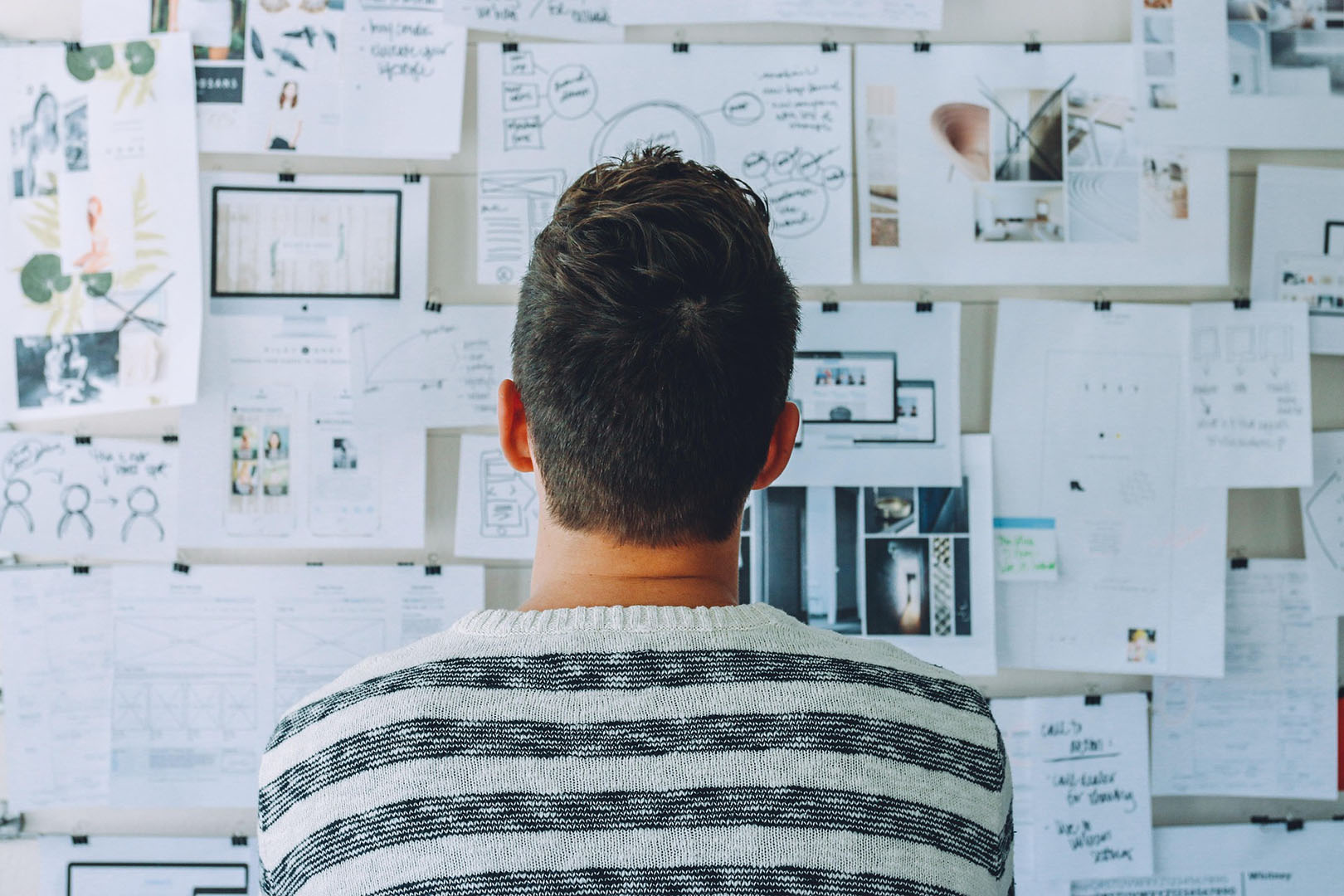 Photo illustrant une personne regarde des documents accrochés au mur